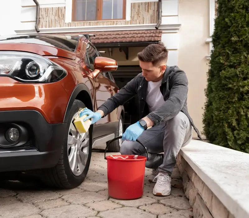Lavage auto à domicile Saint-Julien-les-Rosiers : professionnel intervenant sur un véhicule